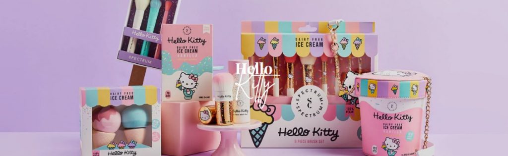 white cat with pink bow holding an ice cream cone. Colorful makeup brushes and makeup sponges.